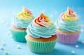 rainbow birthday cupcakes on blue background Royalty Free Stock Photo
