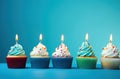 rainbow birthday cupcakes on blue background Royalty Free Stock Photo