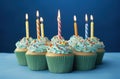 rainbow birthday cupcakes on blue background Royalty Free Stock Photo