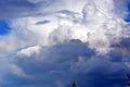 Rainbow in the blue sky above the forest. White clouds float across the sky. A picturesque horizontal landscape Royalty Free Stock Photo