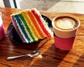 Rainbow Cake with Sprinkles, Cappucino, Spoon in Sunlight Royalty Free Stock Photo