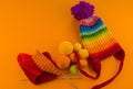 Rainbow cap made of wool on an orange background Royalty Free Stock Photo