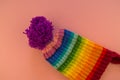 Rainbow cap made of wool on a pink background Royalty Free Stock Photo