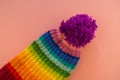 Rainbow cap made of wool on a pink background Royalty Free Stock Photo