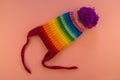 Rainbow cap made of wool on a pink background Royalty Free Stock Photo