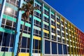 Rainbow cheerful office / residential building with windows. The facade of the house with a palm tree against blue sky in Israel Royalty Free Stock Photo