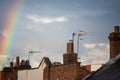 Rainbow over rooftops with storm clouds in background Royalty Free Stock Photo