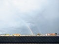 Rainbow in the city over eht hills and houses. Royalty Free Stock Photo