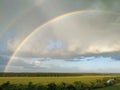 Rainbow and clouds over fields and river, smart Royalty Free Stock Photo