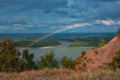 Rainbow with clouds over a river valley Royalty Free Stock Photo