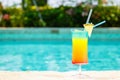 Rainbow cocktail at the edge of a resort pool. Concept of luxur Royalty Free Stock Photo
