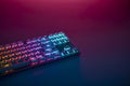 Rainbow Color Backlighted Gaming Keyboard On Desk. Purple Light From Top