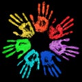 Rainbow color hands print in circle on black background isolated close up, colorful watercolor handprint illustration