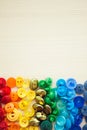 Rainbow colored buttons on wooden background, copy space for your text