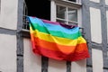 Rainbow colored flag on home windows building on a street in lgbt gay lesbian colors