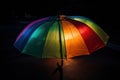 rainbow-colored umbrella with illumination from the inside on a black background Royalty Free Stock Photo