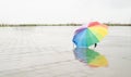 Rainbow colored umbrella lying in puddles on the wet street ground Royalty Free Stock Photo