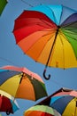 Rainbow colored umbrellas hanging in the sky. Summer travel. LGBT pride Royalty Free Stock Photo