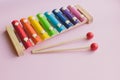 Rainbow Colored Wooden Toy Xylophone on pink bacground. toy glockenspiel made of metal and wood Royalty Free Stock Photo