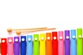 Rainbow colored wooden toy xylophone with two sticks on white background. Royalty Free Stock Photo