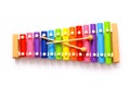 Rainbow colored wooden toy xylophone with two sticks on white background. Royalty Free Stock Photo