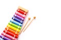 Rainbow colored wooden toy xylophone with two sticks on white background. Royalty Free Stock Photo