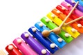 Rainbow colored wooden toy xylophone with two sticks on white background. Royalty Free Stock Photo
