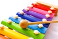 Rainbow colored wooden toy xylophone with two sticks on white background. Royalty Free Stock Photo