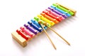Rainbow colored wooden toy xylophone with two sticks on white background. Royalty Free Stock Photo