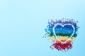 The rainbow of colorful crystals with heart shape for diamond embroidery, mosaic on blue background. Handmade hobby concept. Flat Royalty Free Stock Photo