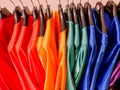 Rainbow colors. Choice of casual clothes on black hangers, isolated on white.Variety of silk dresses on hangers.Colorful Royalty Free Stock Photo