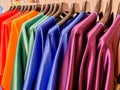 Rainbow colors. Choice of casual clothes on black hangers, isolated on white.Variety of silk dresses on hangers.Colorful Royalty Free Stock Photo