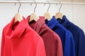 Rainbow colors. Choice of casual clothes on wooden hangers in a store Royalty Free Stock Photo