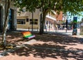 Rainbow coloured bench in sunshine.