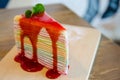 Rainbow crepe cake on wooden plate