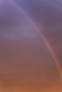 Rainbow in a dramatic sunset sky. Great scenery. Space for text. Background. Blurred. Vertical Royalty Free Stock Photo
