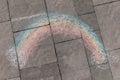 A rainbow drawn with crayons on the road. Rainbow LGBT symbol on the asphalt pavement. Creativity of children in the yard. Royalty Free Stock Photo