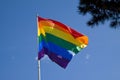 Rainbow flag with blue sky background - LGBT symbol - for gay, lesbian, bisexual or transgender relationship, love or sexuality