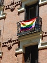 Rainbow flag of gay community on the balcony of classical building downtown Madrid, Spain. Vertical photo