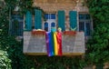 Rainbow LGBT flag hanging from the balcony of an old building