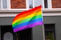 Rainbow flag waving in city at pride parade - LGBT symbol - for gay, lesbian, bisexual or transgender relationship, love or sexual