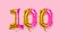 Rainbow foil balloon number, digit one hundred on a pink background. Birthday greeting card with inscription 100 Royalty Free Stock Photo