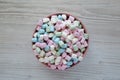 Rainbow Fruity Mini Marshmallows in a Pink Bowl on a white wooden background, top view. Flat lay, overhead, from above Royalty Free Stock Photo