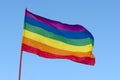 Rainbow Gay Pride Flag on blue sky background, USA Royalty Free Stock Photo