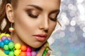 Rainbow girl. Model with colorful bright jewelry. Woman with neat makeup and high hairstyle with colored necklace and earrings