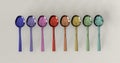 Rainbow glossy color metal spoons arranged in line