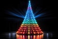 Rainbow glowing Christmas tree made of lanterns on a black background. New Year banner, postcard Royalty Free Stock Photo