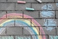 Rainbow with grass and clouds painted in colored chalk on a path on the street Royalty Free Stock Photo