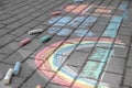 Rainbow with grass, house and clouds painted in colored chalk on a path on the street Royalty Free Stock Photo