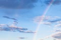 Rainbow and gray clouds in blue evening sky Royalty Free Stock Photo